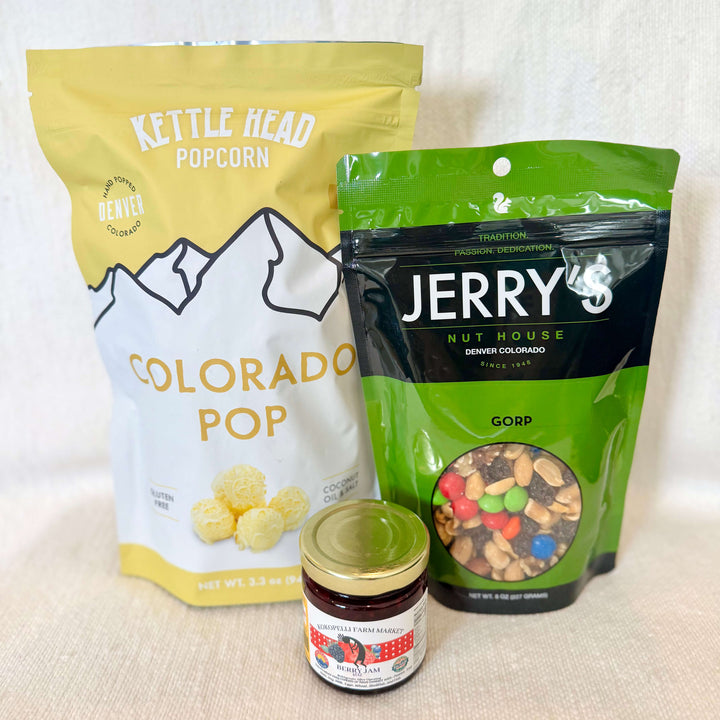 A little taste of Colorado, all wrapped up and ready to gift. Our Colorado Snack Pack Gift Set features a delicious lineup of locally loved favorites, including our best-selling Kettle Head popcorn, Jerry’s Nut House trail mix, and a jar of locally made Colorado jam.