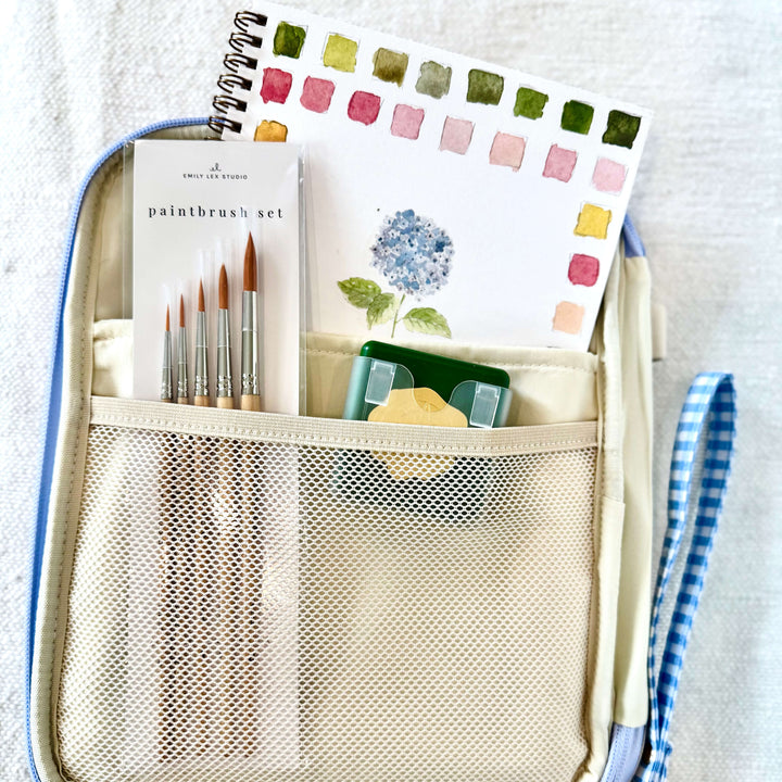 Our Create and Inspire Gift Set is designed for creatives, makers, and anyone who loves a little artistic escape. This thoughtfully curated set includes an Emily Lex water color paint color book, watercolor set, paint brushes, and a stylish clutch to keep all your art supplies organized in one place.