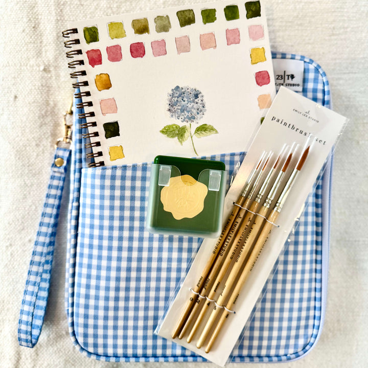 Our Create and Inspire Gift Set is designed for creatives, makers, and anyone who loves a little artistic escape. This thoughtfully curated set includes an Emily Lex water color paint color book, watercolor set, paint brushes, and a stylish clutch to keep all your art supplies organized in one place.