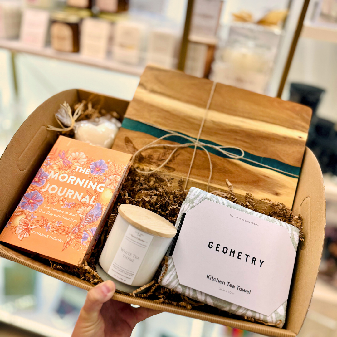 Gift box with 'The Morning Journal', candle, and 'Geometry' kitchen tea towel, resin cutting board, candle and heart soap.