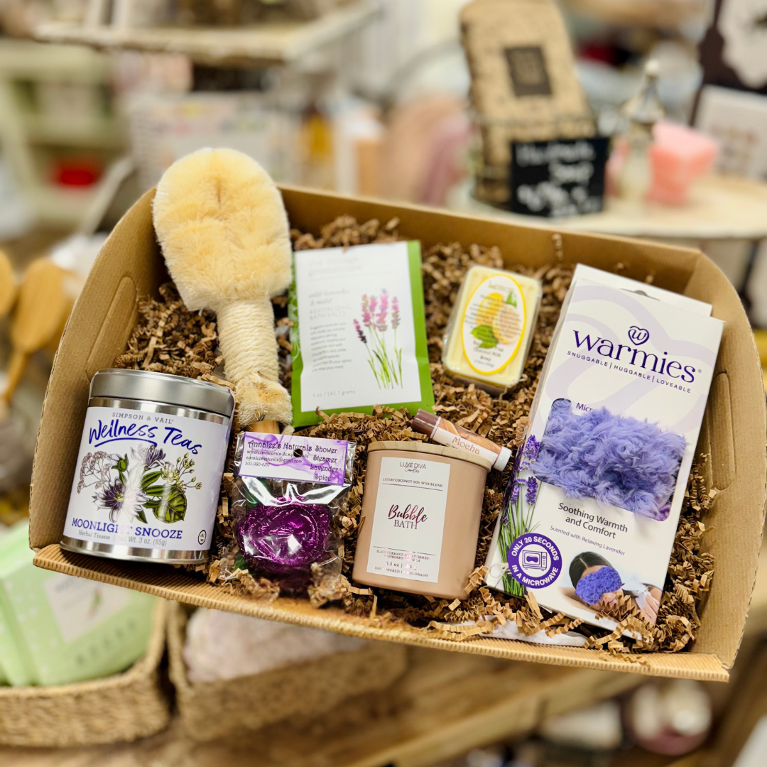 Self Care Gifting box with wellness products including candles, tea, bath salts, warmies, eye mask