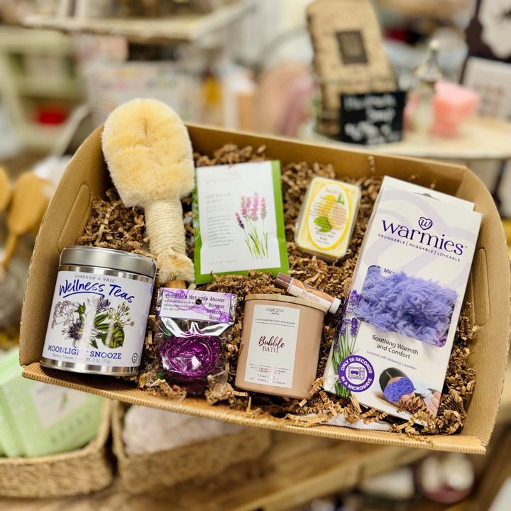 Self Care Gifting box with wellness products including candles, tea, bath salts, warmies, eye mask